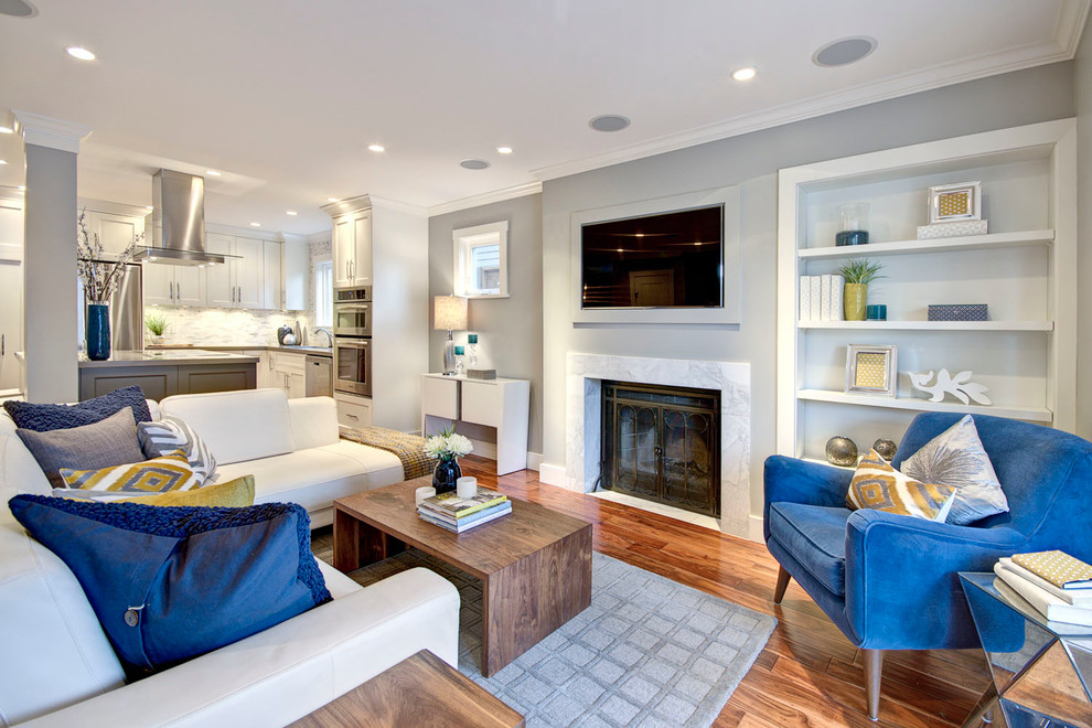 Offenes Modernes Wohnzimmer mit blauer Wandfarbe, braunem Holzboden und TV-Wand in Vancouver