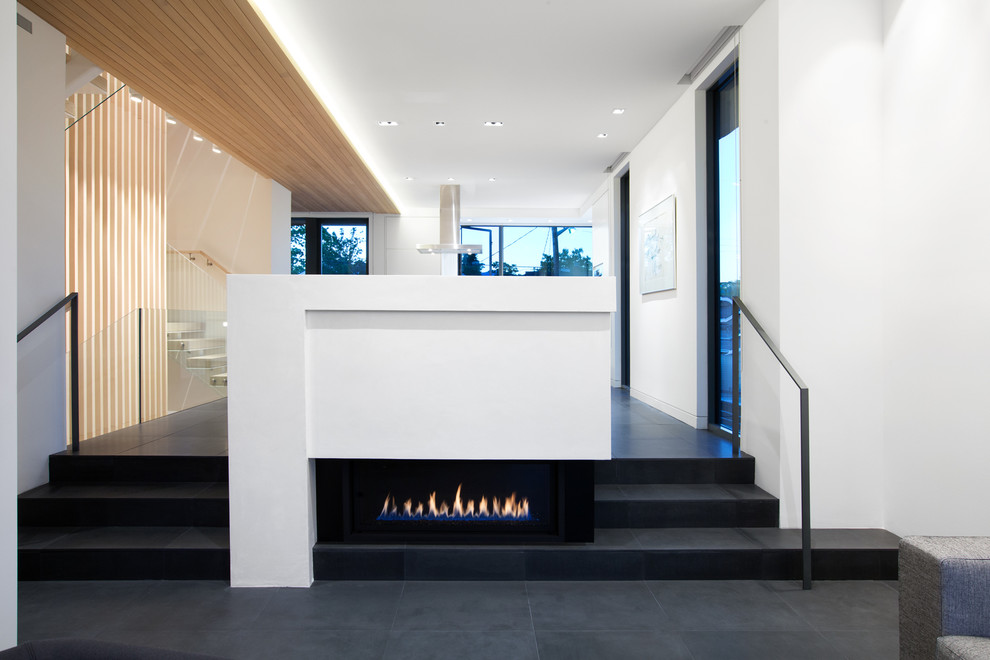 Réalisation d'un petit salon design ouvert avec une salle de réception, un mur blanc, un sol en ardoise et un manteau de cheminée en métal.