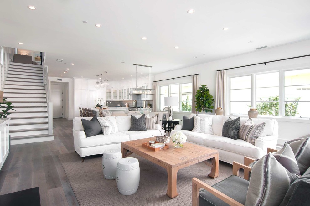 Idee per un soggiorno stile marino aperto con pareti bianche, parquet scuro, camino classico e pavimento grigio