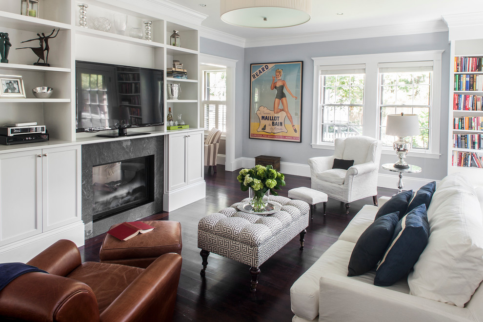 Inspiration for a mid-sized timeless enclosed dark wood floor living room library remodel in Boston with a two-sided fireplace, a stone fireplace, a media wall and gray walls