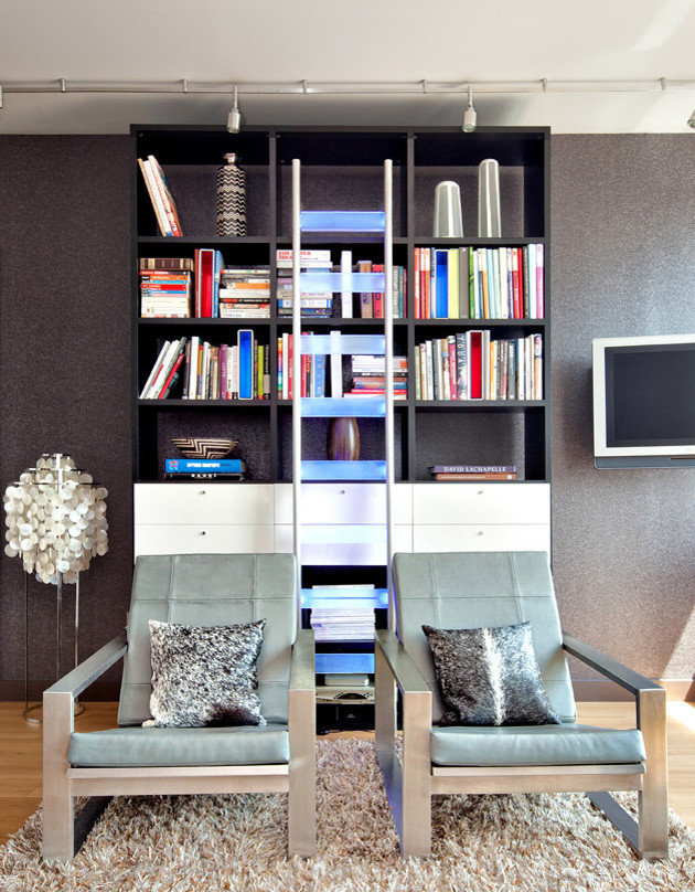 Réalisation d'un salon minimaliste de taille moyenne et ouvert avec une bibliothèque ou un coin lecture, un mur gris, un sol en bois brun et un téléviseur fixé au mur.