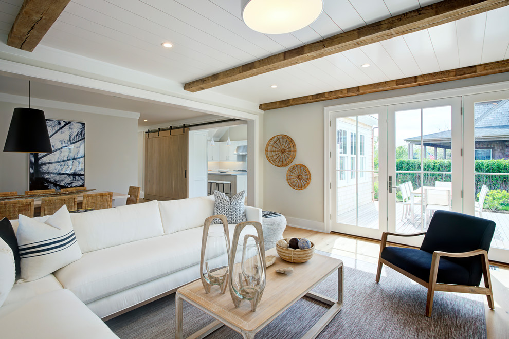 Esempio di un soggiorno costiero aperto con pareti beige, pavimento in legno massello medio e pavimento marrone