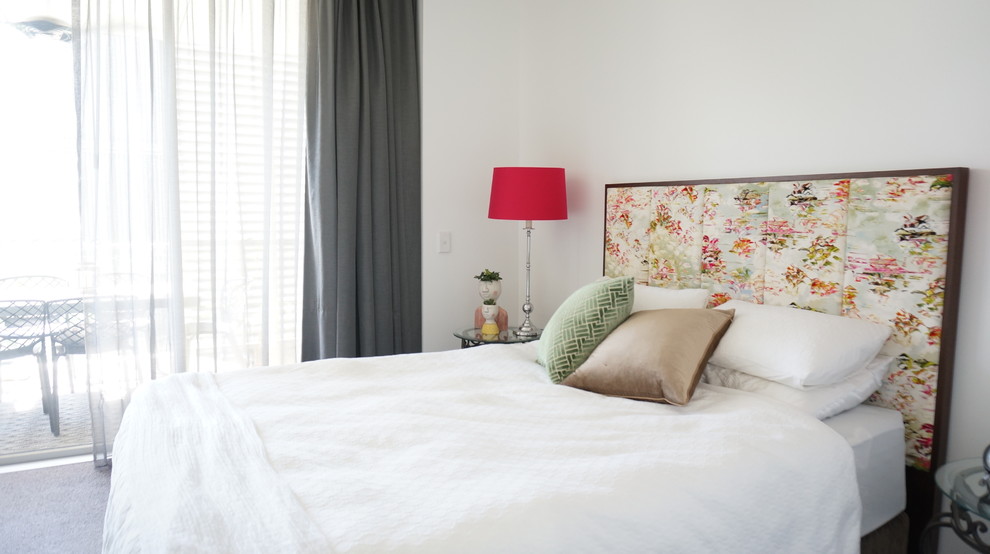 Immagine di una piccola camera da letto moderna con pareti bianche, pavimento in laminato, nessun camino e pavimento marrone
