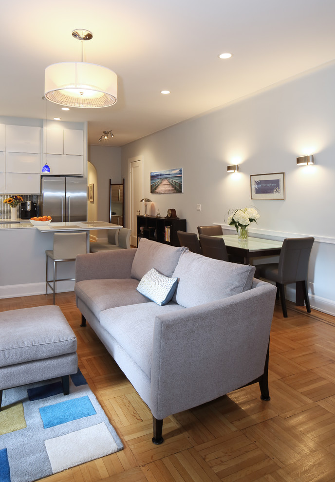 This is an example of a small contemporary open plan living room in New York with blue walls, medium hardwood flooring and a wall mounted tv.