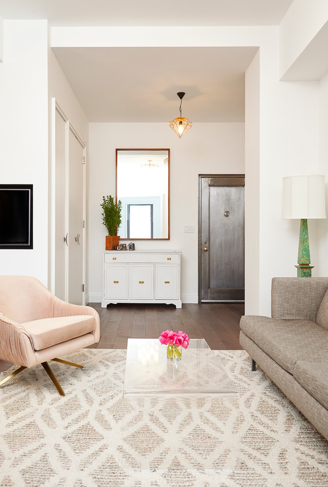 Diseño de salón abierto actual pequeño con paredes blancas, suelo de madera en tonos medios y televisor retractable