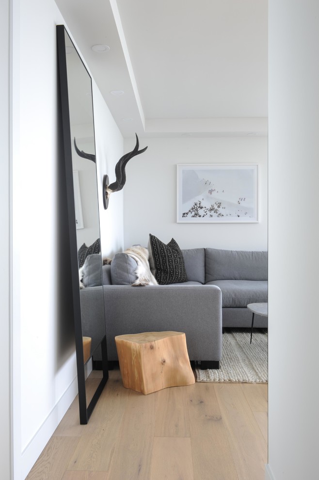 Ispirazione per un piccolo soggiorno minimalista aperto con pareti nere, parquet chiaro, parete attrezzata e pavimento marrone