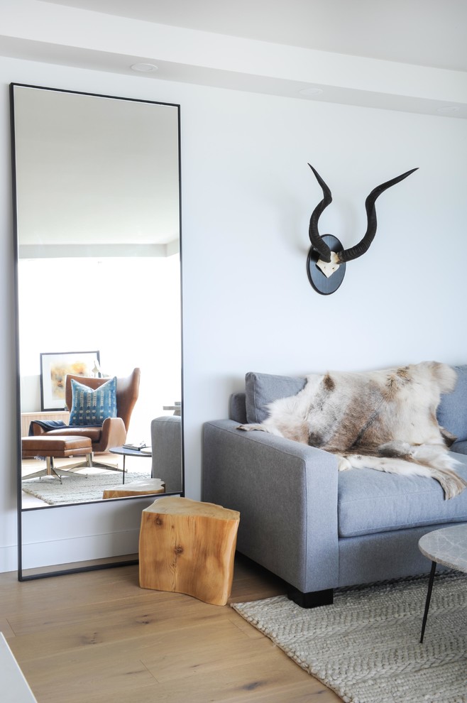 Immagine di un piccolo soggiorno minimalista aperto con pareti nere, parquet chiaro, parete attrezzata e pavimento marrone