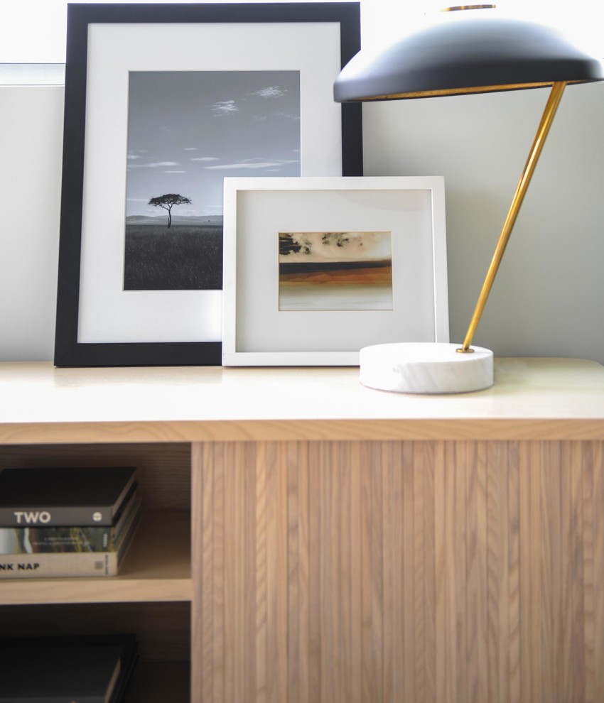 Imagen de salón abierto minimalista pequeño con paredes negras, suelo de madera clara, pared multimedia y suelo marrón