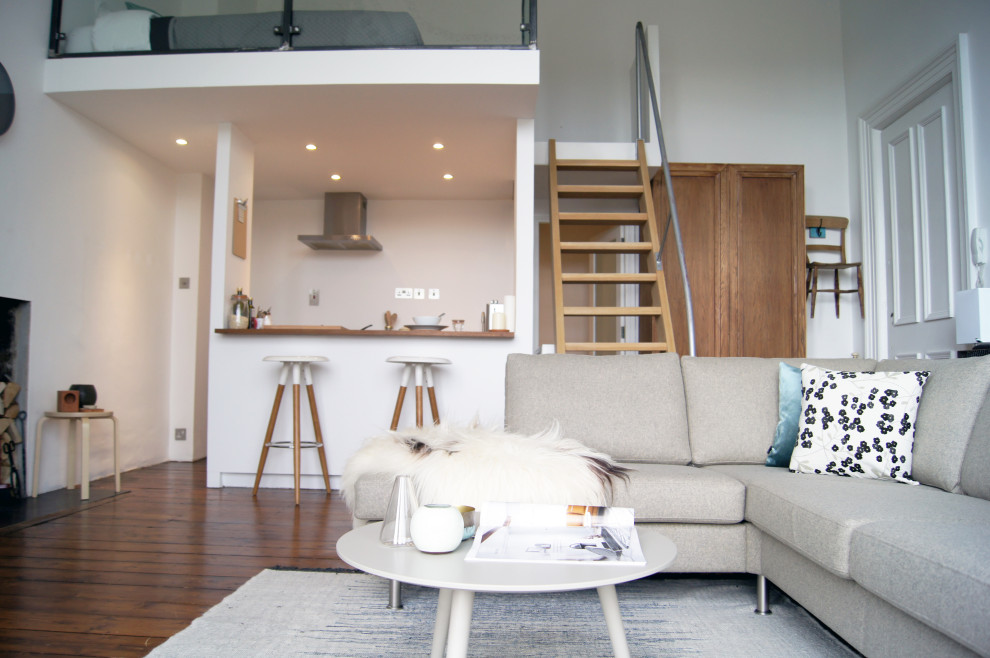 Mittelgroßes, Offenes Skandinavisches Wohnzimmer mit weißer Wandfarbe, dunklem Holzboden, freistehendem TV und braunem Boden in Glasgow