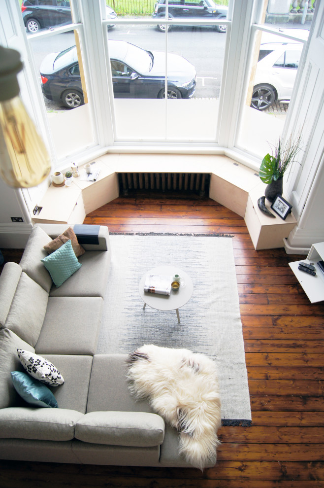 グラスゴーにあるお手頃価格の中くらいな北欧スタイルのおしゃれなLDK (白い壁、濃色無垢フローリング、据え置き型テレビ、茶色い床) の写真