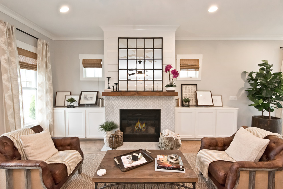 Idée de décoration pour un salon champêtre avec un mur gris, un sol en bois brun, une cheminée standard, un manteau de cheminée en pierre et un sol blanc.