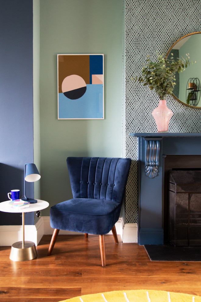 ロンドンにあるお手頃価格の中くらいなトランジショナルスタイルのおしゃれなLDK (青い壁、濃色無垢フローリング、木材の暖炉まわり、壁掛け型テレビ、茶色い床) の写真