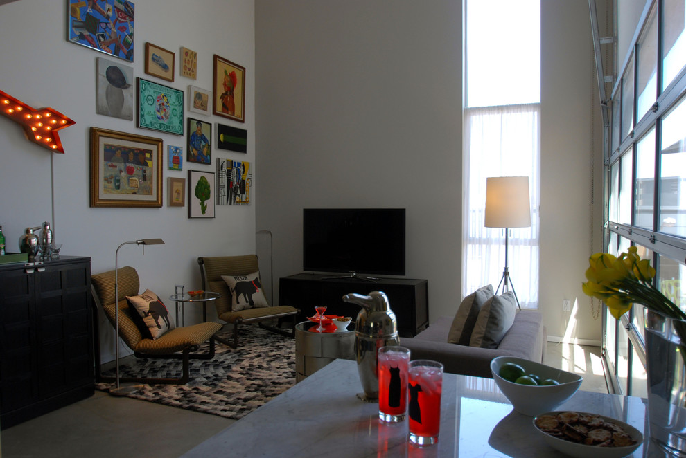 Mittelgroßes Modernes Wohnzimmer im Loft-Stil mit freistehendem TV, grauer Wandfarbe und Betonboden in Los Angeles