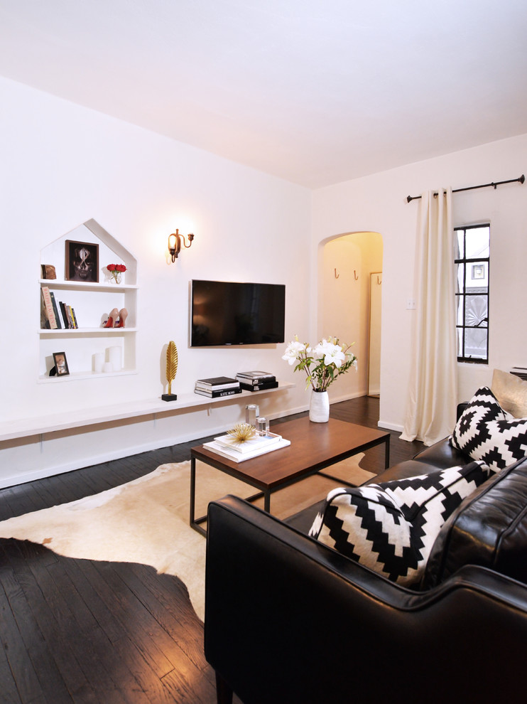 Imagen de salón abierto retro pequeño con paredes blancas, suelo de madera oscura y televisor colgado en la pared
