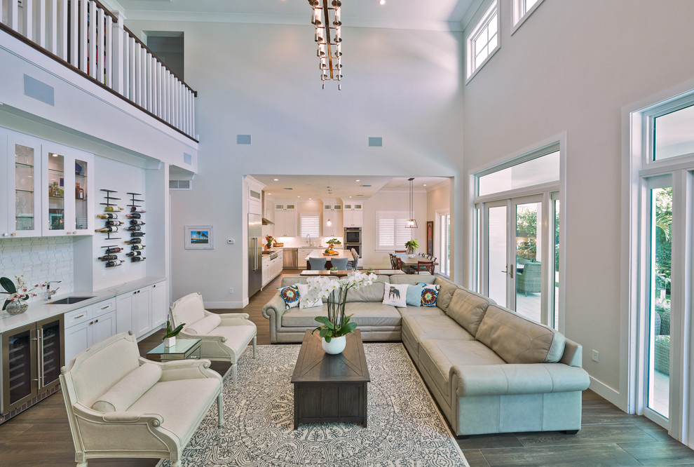 Esempio di un soggiorno tropicale stile loft con angolo bar, pareti grigie e pavimento marrone