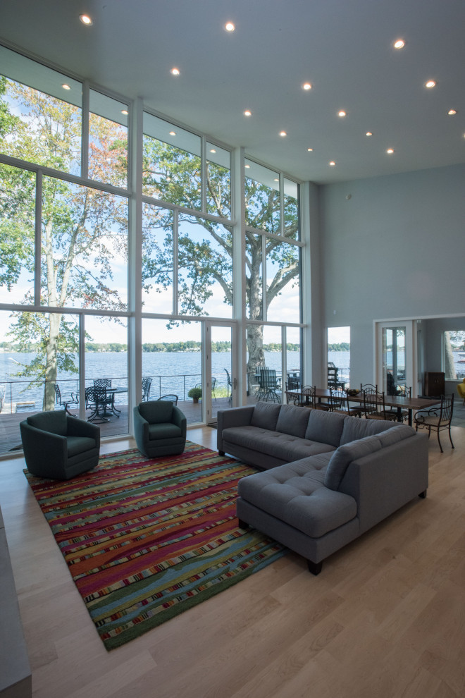 Immagine di un grande soggiorno contemporaneo aperto con pareti grigie, parquet chiaro e soffitto a volta