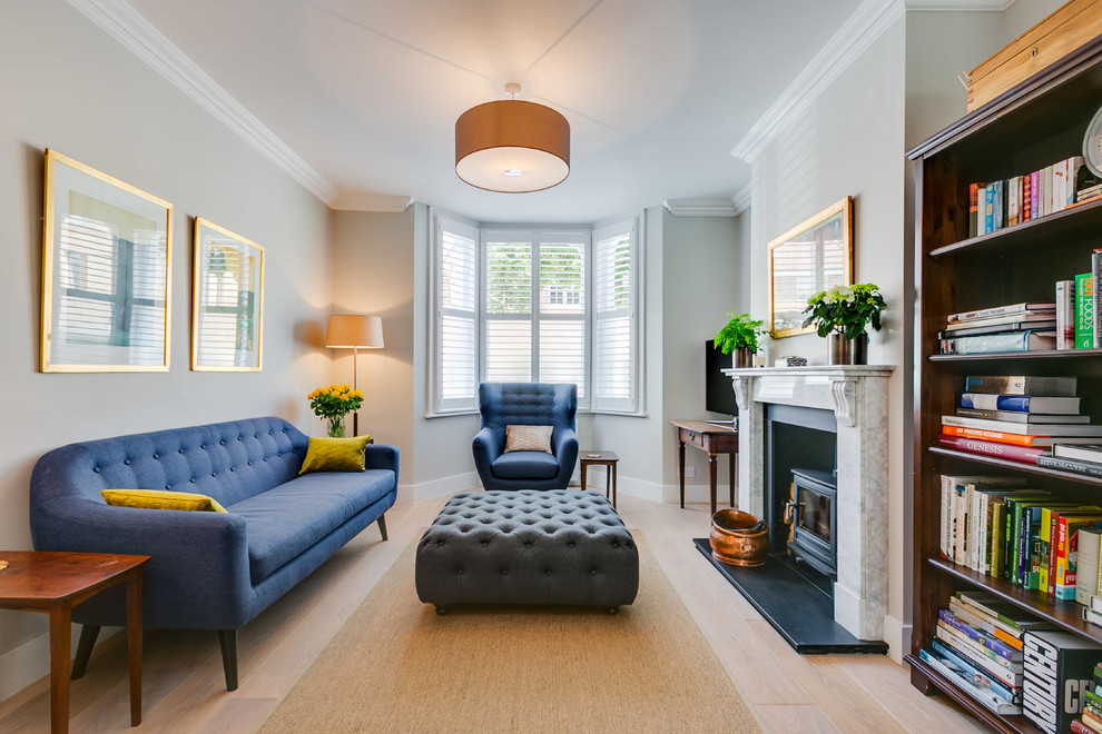 Esempio di un soggiorno classico di medie dimensioni e chiuso con pareti grigie, parquet chiaro, pavimento beige, stufa a legna e TV autoportante