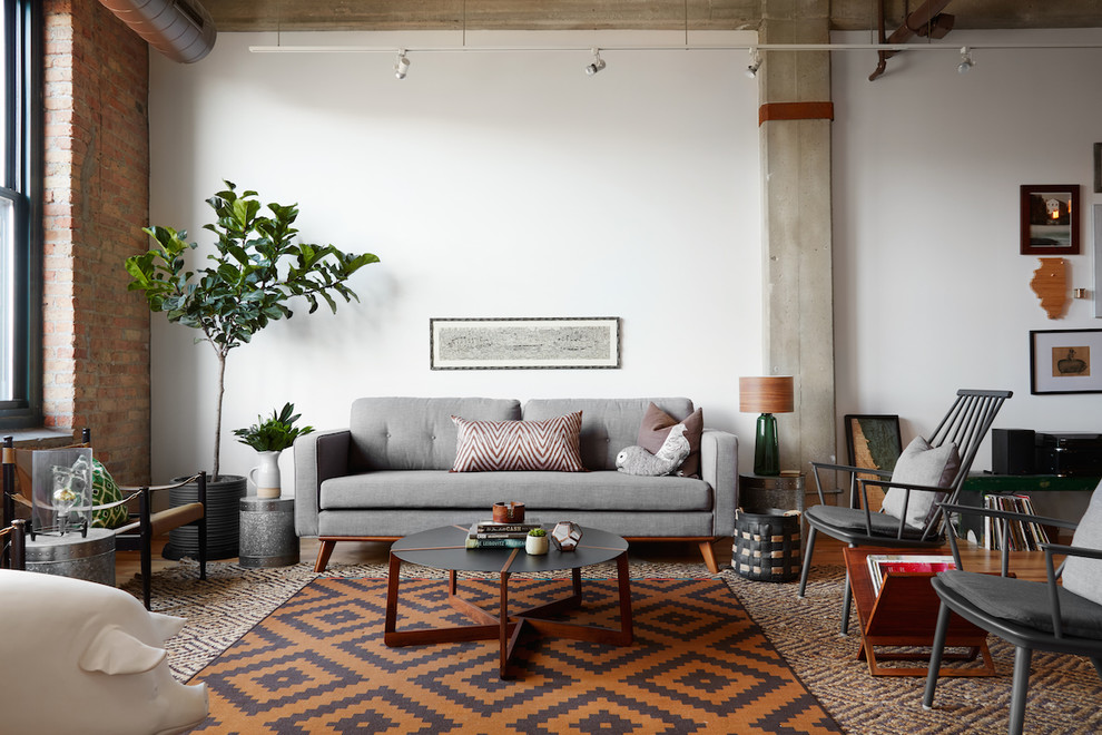 Trendy medium tone wood floor living room photo in Chicago with white walls