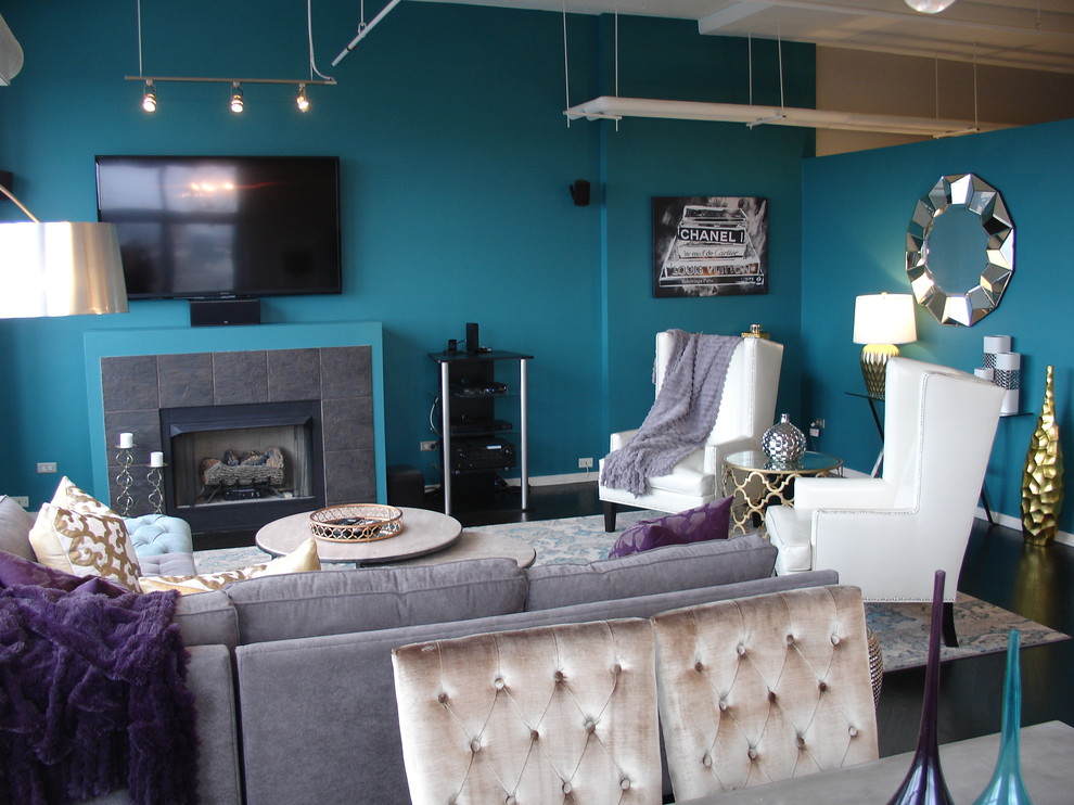 Идея дизайна: парадная, двухуровневая гостиная комната среднего размера в стиле модернизм с синими стенами, темным паркетным полом, стандартным камином, фасадом камина из плитки и телевизором на стене