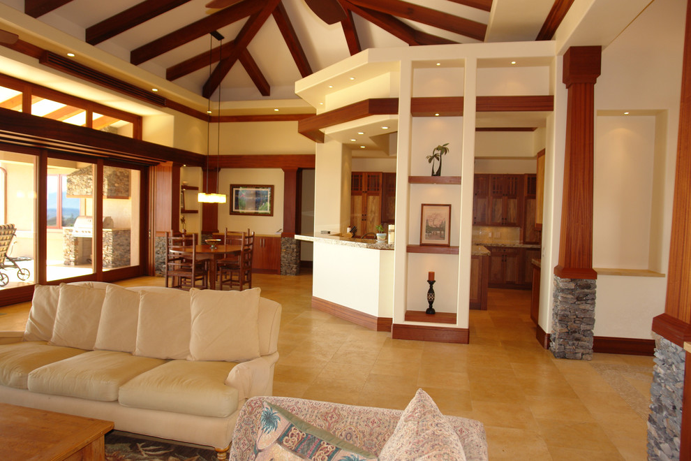 Idee per un ampio soggiorno tropicale aperto con angolo bar, pareti beige, pavimento in pietra calcarea e TV a parete