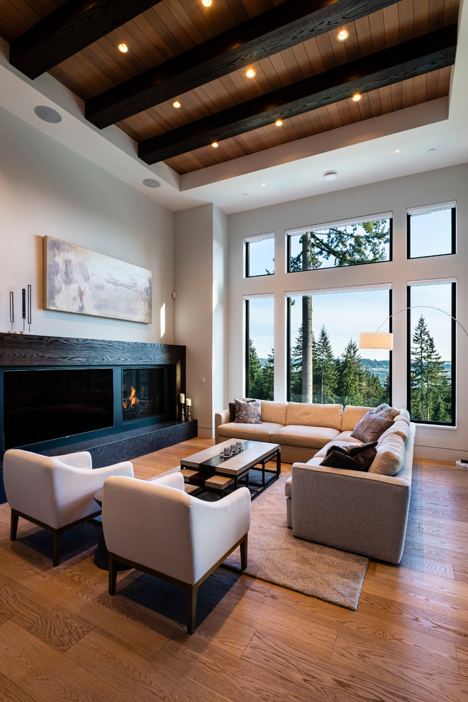 Aménagement d'un grand salon classique ouvert avec un mur blanc, parquet clair, une cheminée standard, un manteau de cheminée en bois, un téléviseur encastré et un sol beige.