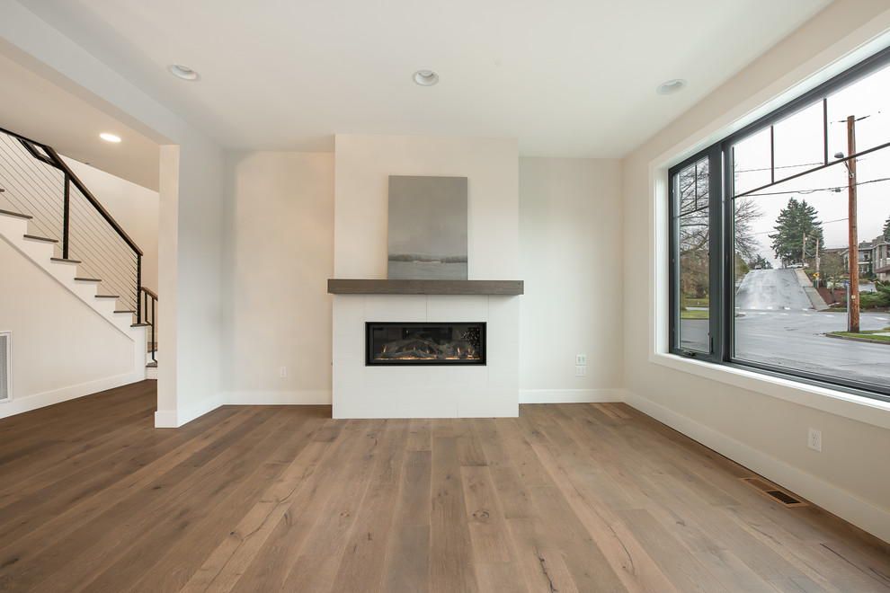 Großes, Fernseherloses, Offenes Modernes Wohnzimmer mit weißer Wandfarbe, braunem Holzboden, Gaskamin und braunem Boden in Seattle