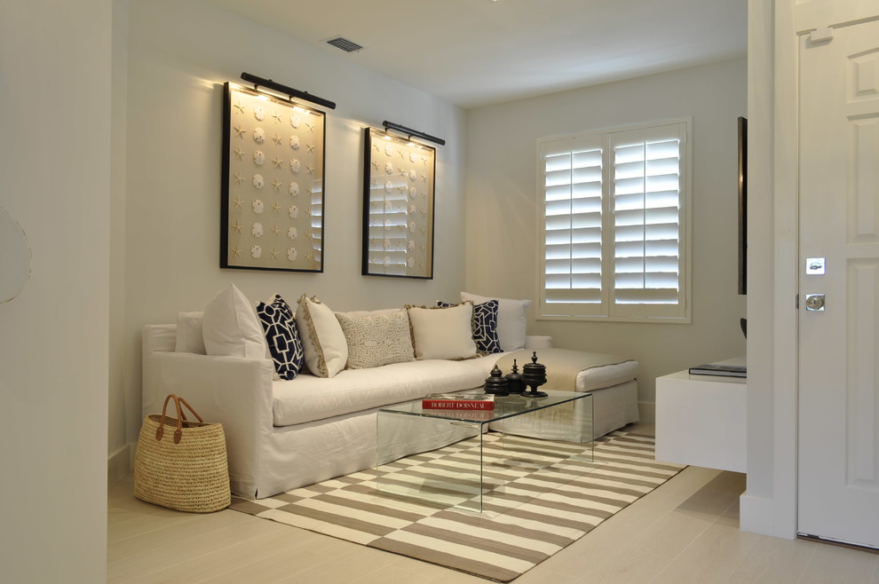 Inspiration for a mid-sized coastal open concept light wood floor living room remodel in Miami with white walls, no fireplace and a media wall