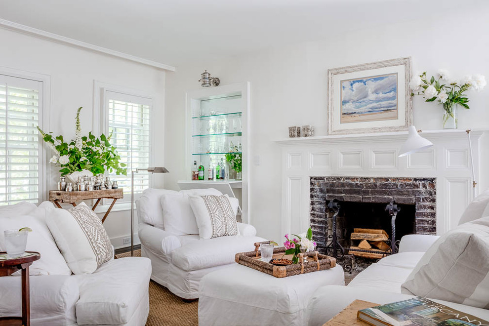 Kleines, Abgetrenntes Shabby-Chic Wohnzimmer mit weißer Wandfarbe, braunem Holzboden, Kamin, Kaminumrandung aus Backstein und braunem Boden in Boston