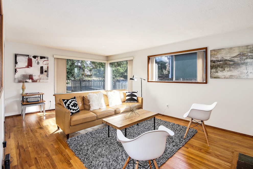 Repräsentatives Retro Wohnzimmer mit grauer Wandfarbe, braunem Holzboden, Kamin und Kaminumrandung aus Backstein in Seattle