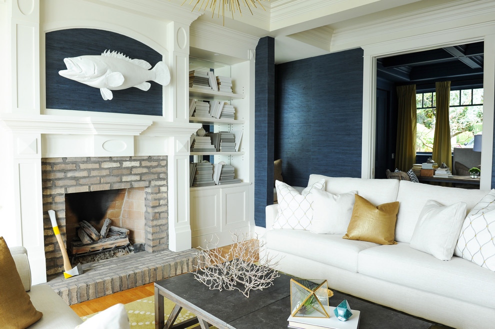 Идея дизайна: открытая гостиная комната среднего размера в морском стиле с с книжными шкафами и полками, синими стенами, светлым паркетным полом, стандартным камином, фасадом камина из кирпича и коричневым полом без телевизора