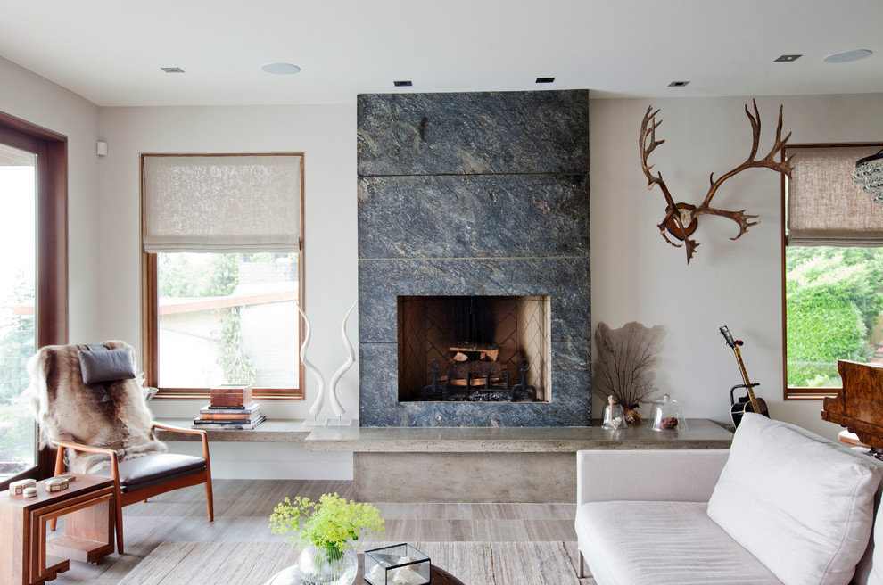バンクーバーにある広いコンテンポラリースタイルのおしゃれなリビング (白い壁、標準型暖炉、タイルの暖炉まわり、茶色い床) の写真