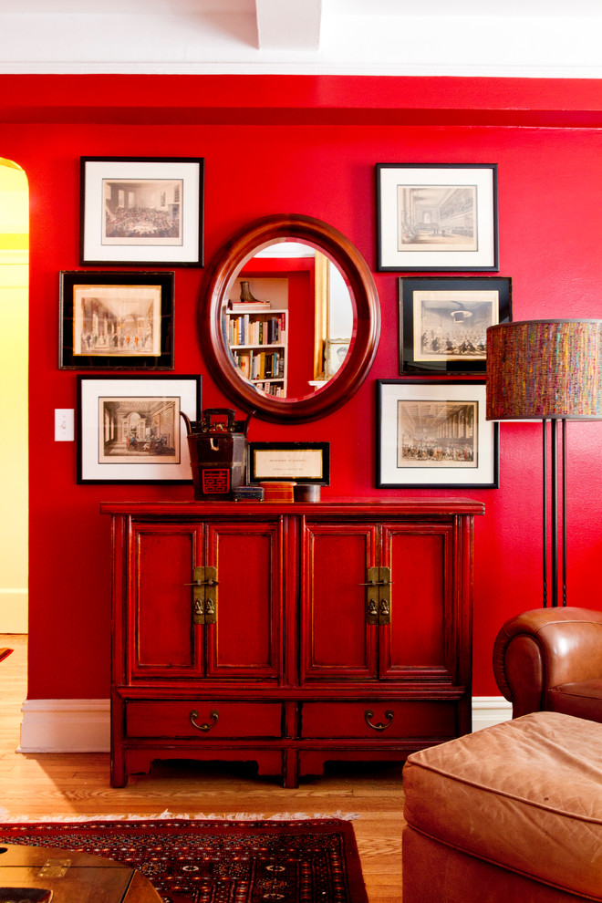 Aménagement d'un salon classique de taille moyenne et ouvert avec un mur rouge et parquet clair.