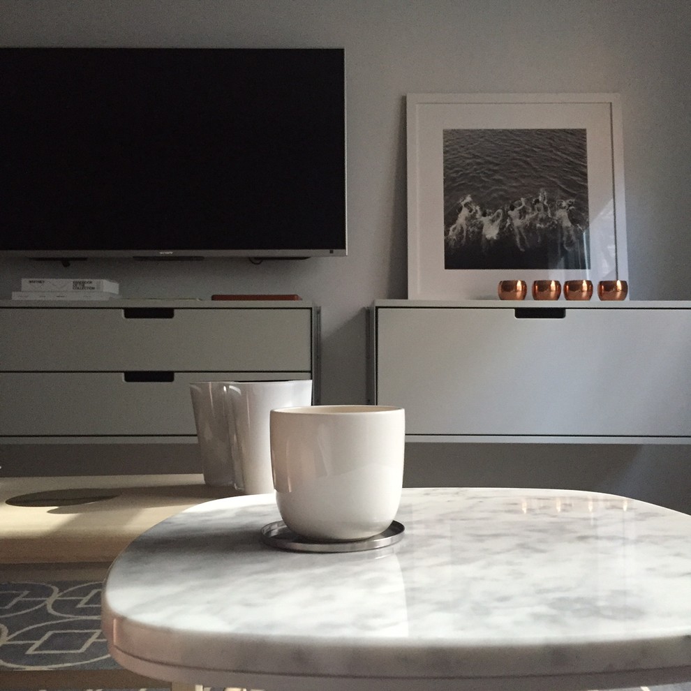 Idee per un soggiorno scandinavo di medie dimensioni e aperto con pareti grigie, pavimento in legno massello medio e TV a parete