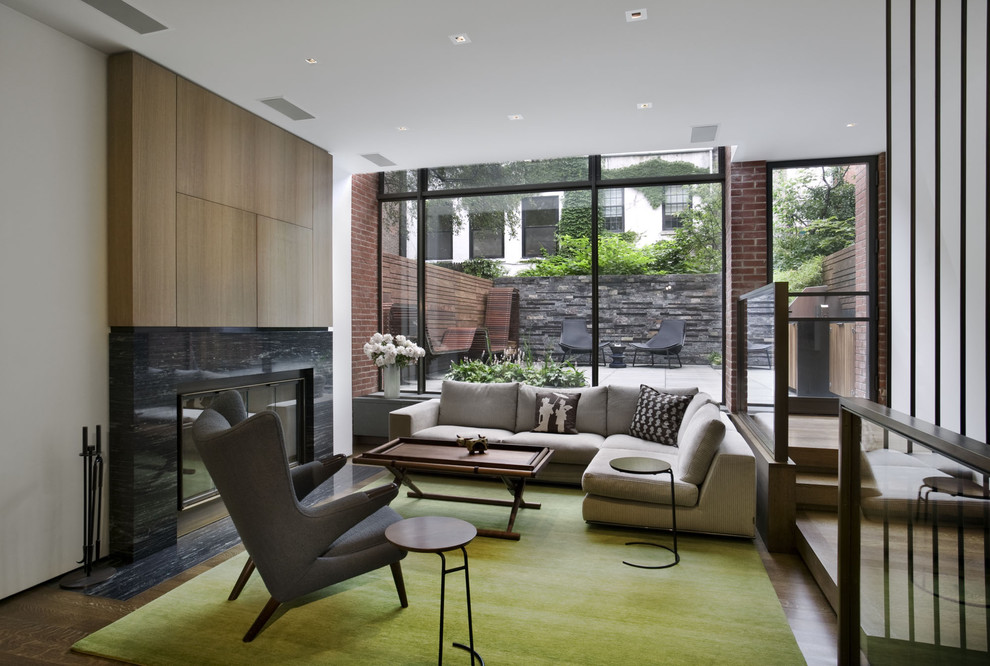 Contemporary living room in New York with a standard fireplace.