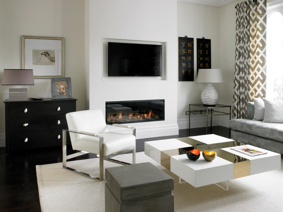Diseño de salón abierto actual de tamaño medio con paredes beige, suelo de madera oscura, chimenea lineal y televisor colgado en la pared