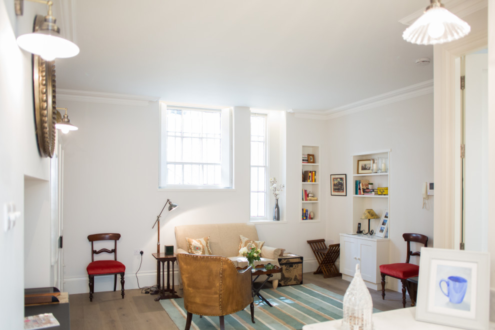 Idée de décoration pour un petit salon design ouvert avec un mur blanc et un sol beige.