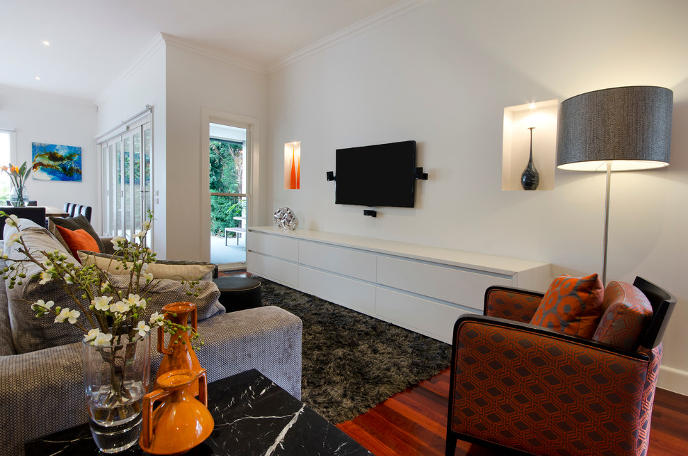 Diseño de salón abierto actual grande con paredes blancas, televisor colgado en la pared y suelo de madera oscura
