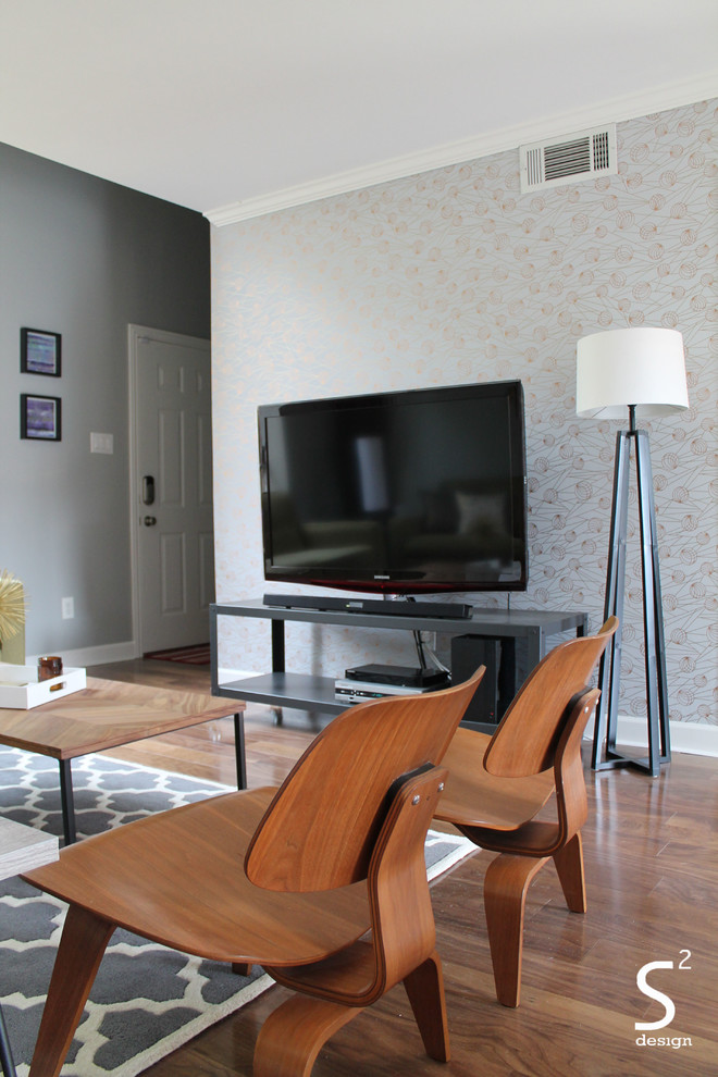 Esempio di un soggiorno minimalista di medie dimensioni e aperto con pareti grigie, pavimento in legno massello medio e TV autoportante