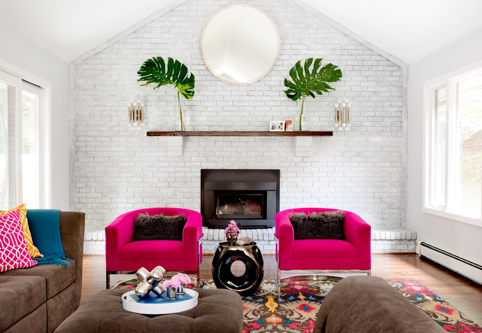 Exemple d'un grand salon tendance ouvert avec un mur gris, un sol en bois brun, une cheminée standard, un téléviseur indépendant et un manteau de cheminée en brique.