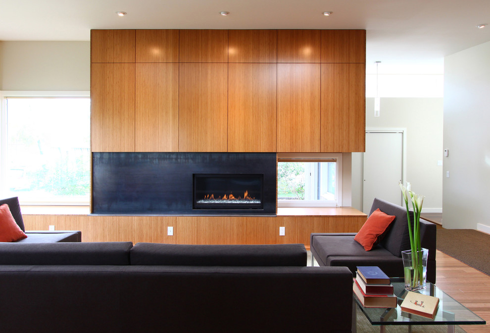 Modernes Wohnzimmer mit weißer Wandfarbe, braunem Holzboden, Gaskamin und Kaminumrandung aus Metall in Seattle