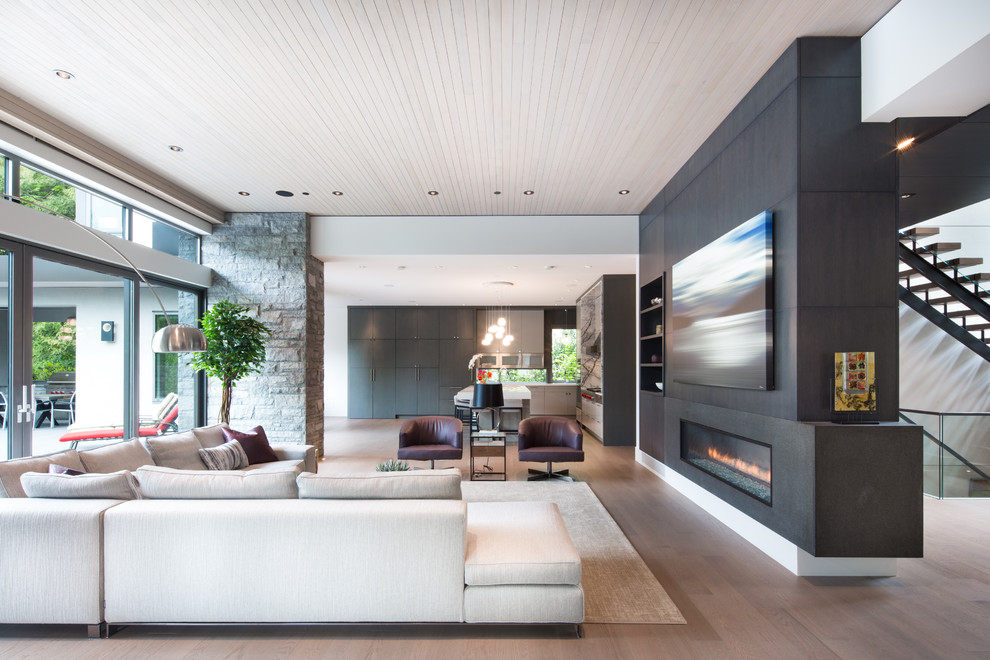 Inspiration for a contemporary open concept medium tone wood floor and brown floor living room remodel in Vancouver with white walls and a ribbon fireplace
