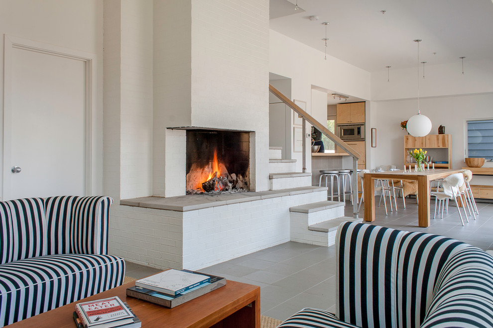 Cette image montre un salon design avec un manteau de cheminée en brique et une cheminée d'angle.