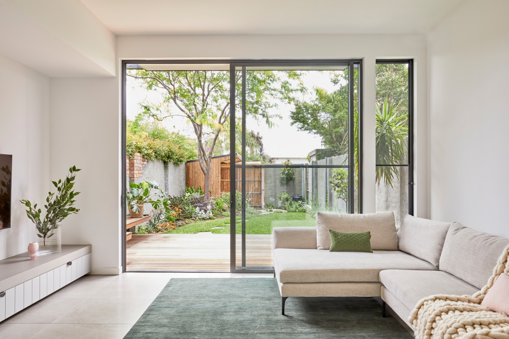 Modernes Wohnzimmer mit weißer Wandfarbe, TV-Wand und grauem Boden in Melbourne