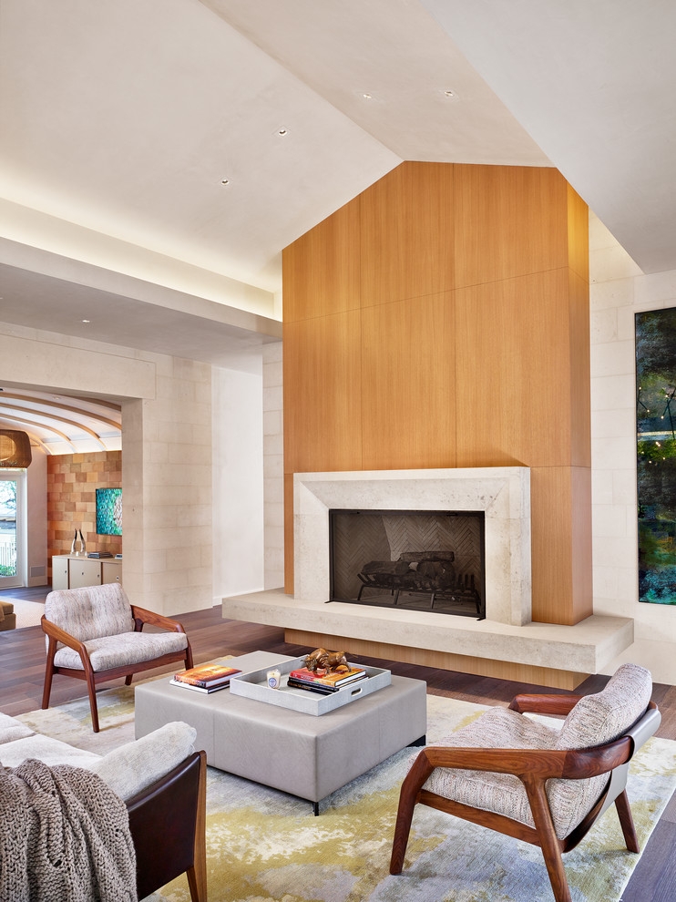 На фото: открытая гостиная комната в современном стиле с паркетным полом среднего тона, стандартным камином, фасадом камина из плитки и ковром на полу с