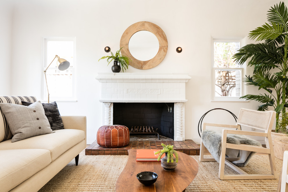Inspiration for a mediterranean living room in Los Angeles with white walls, medium hardwood flooring, a standard fireplace, brown floors and feature lighting.