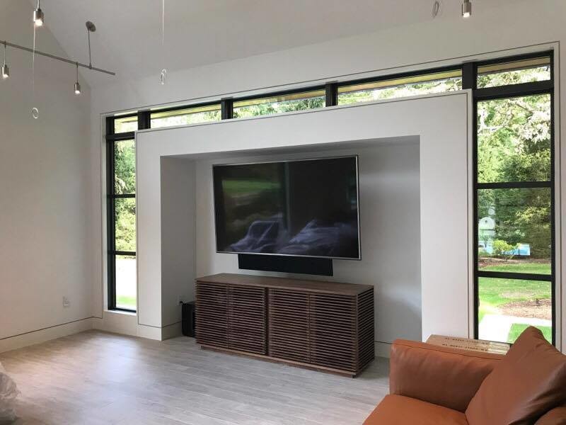 На фото: открытая гостиная комната среднего размера в современном стиле с белыми стенами, светлым паркетным полом, телевизором на стене и серым полом без камина