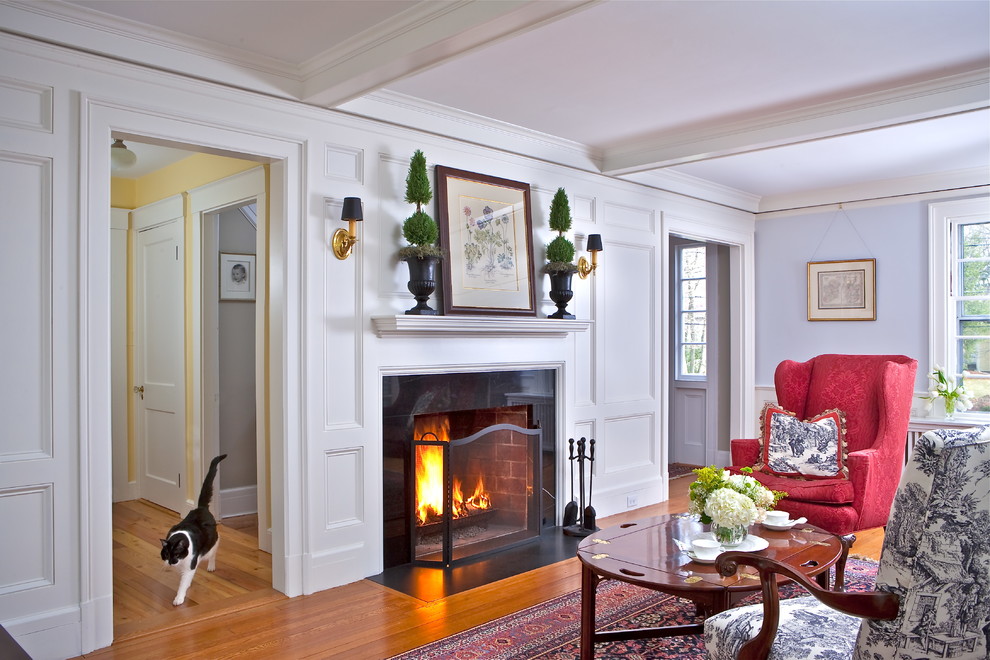 Example of a large classic formal and enclosed medium tone wood floor living room design in Boston with blue walls, a standard fireplace, a stone fireplace and no tv
