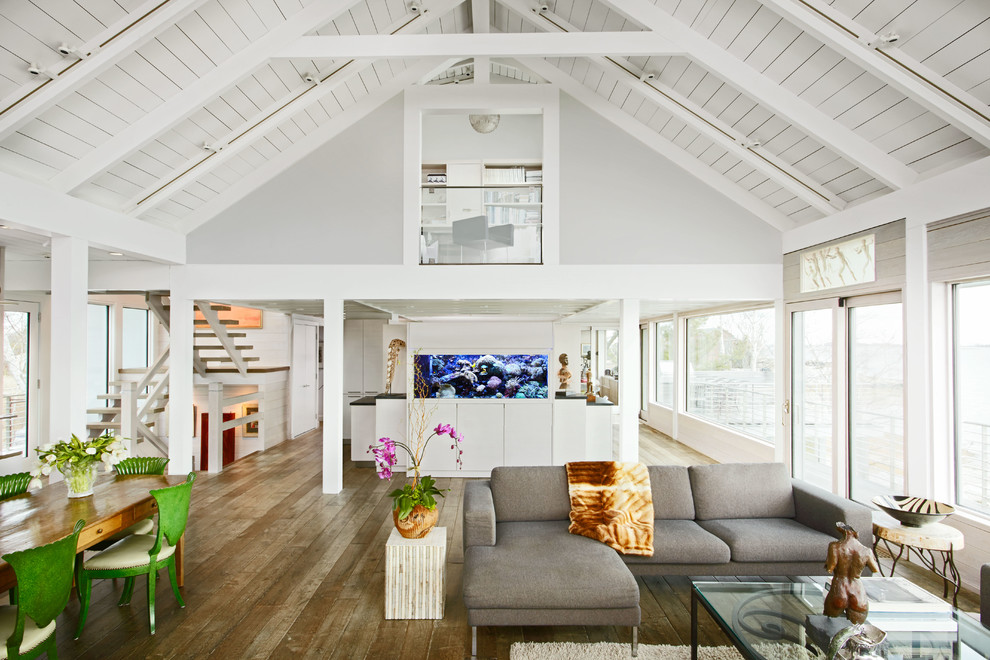 Immagine di un grande soggiorno design aperto con sala formale, pareti grigie e pavimento in legno massello medio