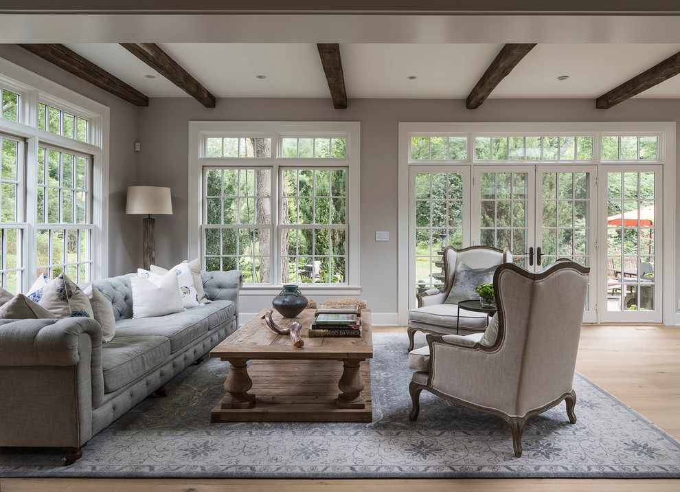 Country open concept light wood floor living room photo in New York with gray walls and no fireplace
