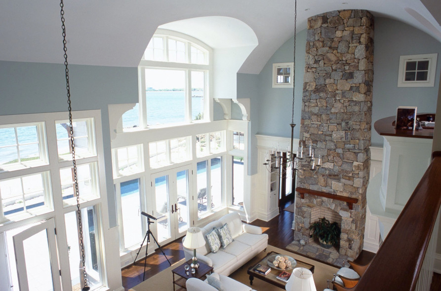 Ispirazione per un grande soggiorno stile marinaro stile loft con pareti blu, moquette, camino classico e cornice del camino in pietra